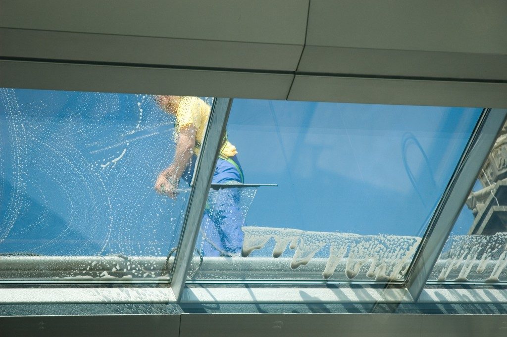 Worker cleaning the building's window
