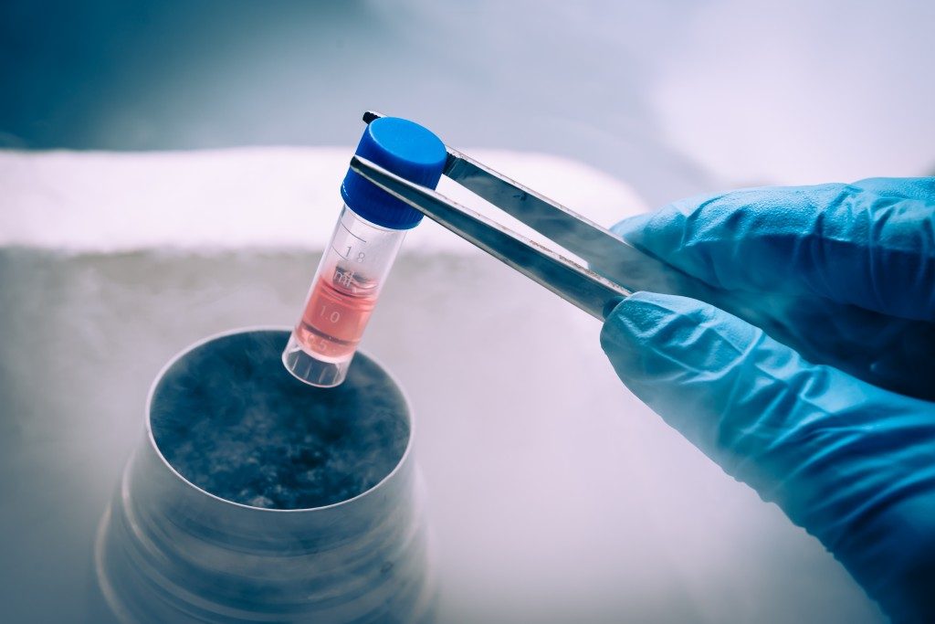 scientist putting vial into cryo pot