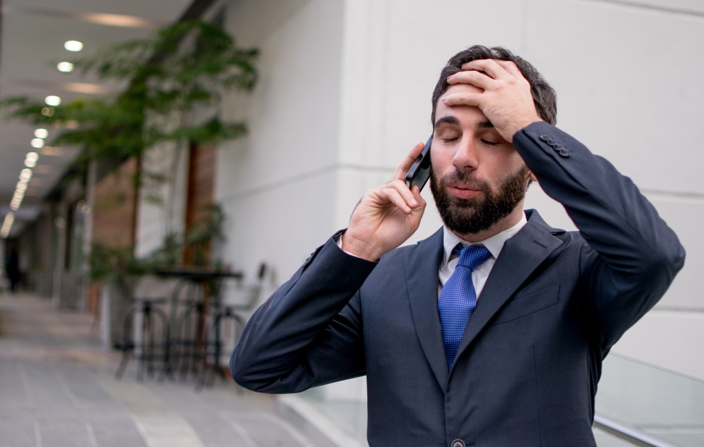 Business man talking on the phone while troubled