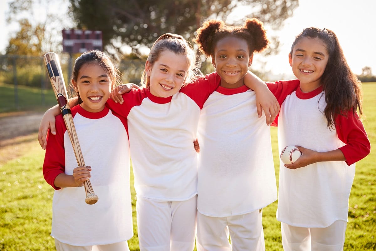 four girls playing baseball