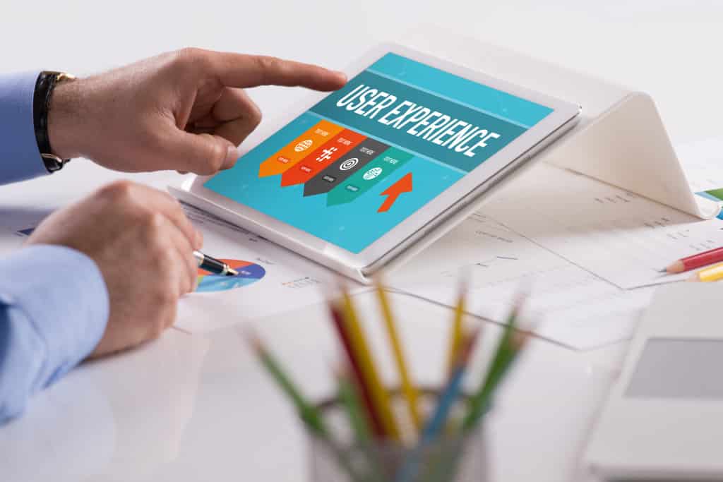 Businessman working on tablet with USER EXPERIENCE on a screen