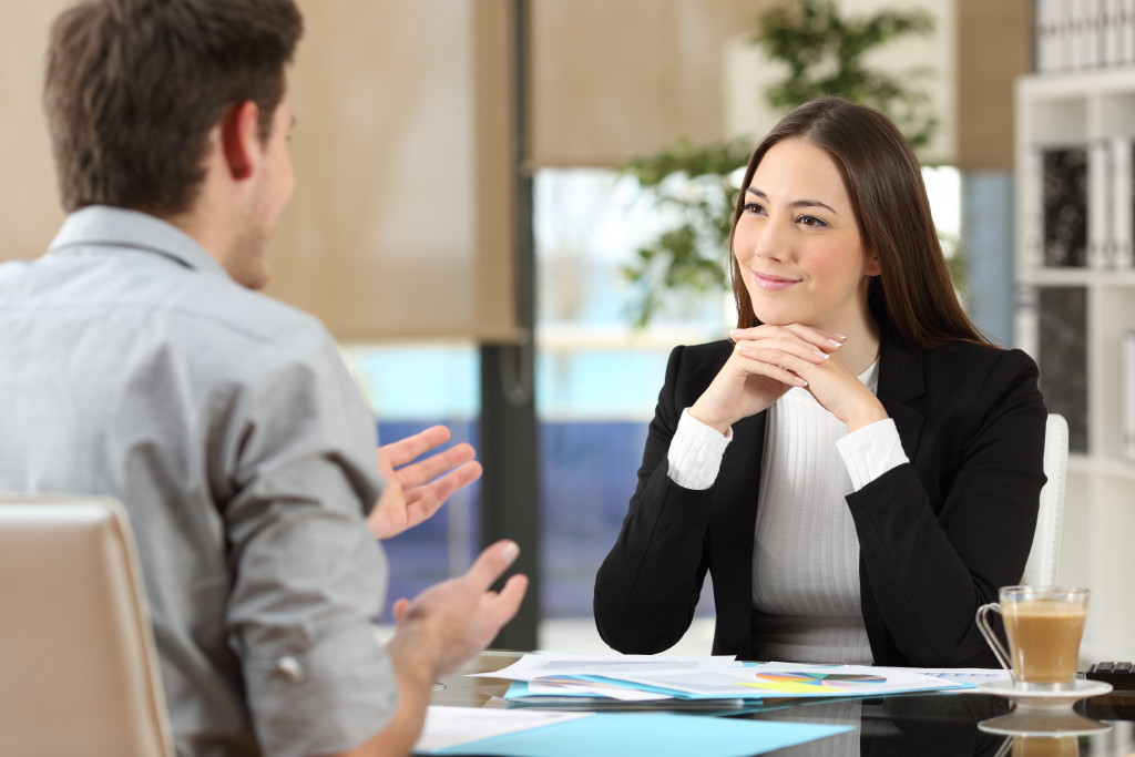 Female interviewer interviewing young male candidate in office