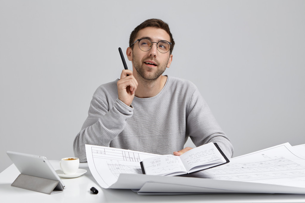 man making a plan with busy desktop