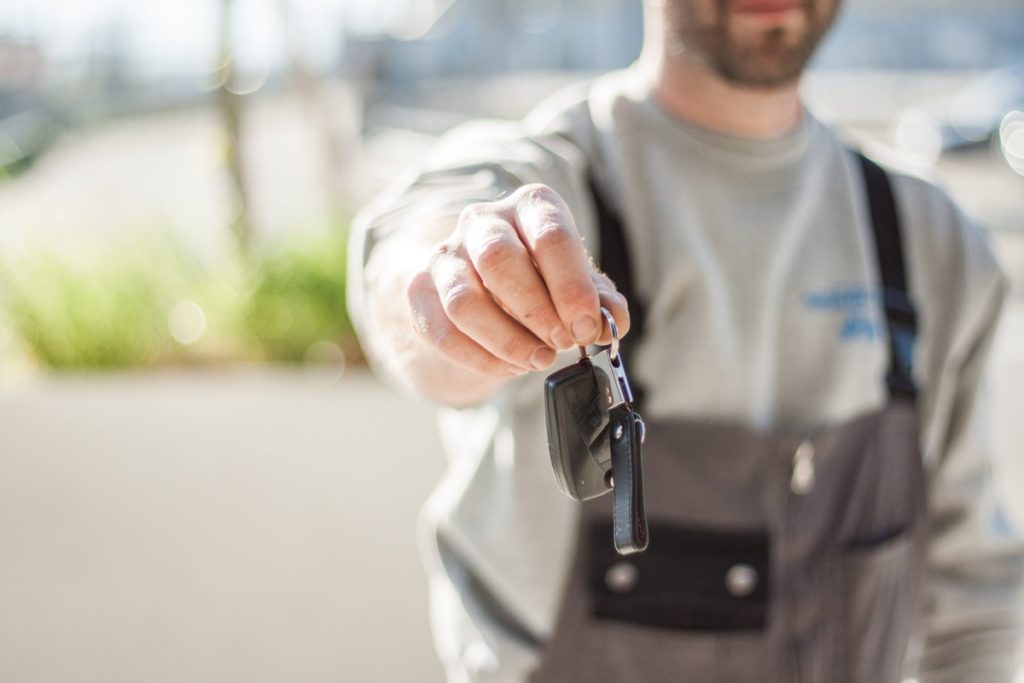 car rental personnel handing keys to car