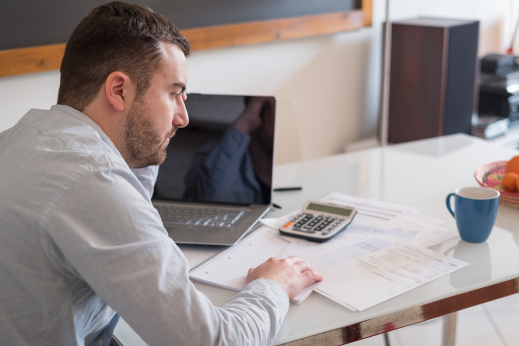 frustrated man calculating bills and tax expense