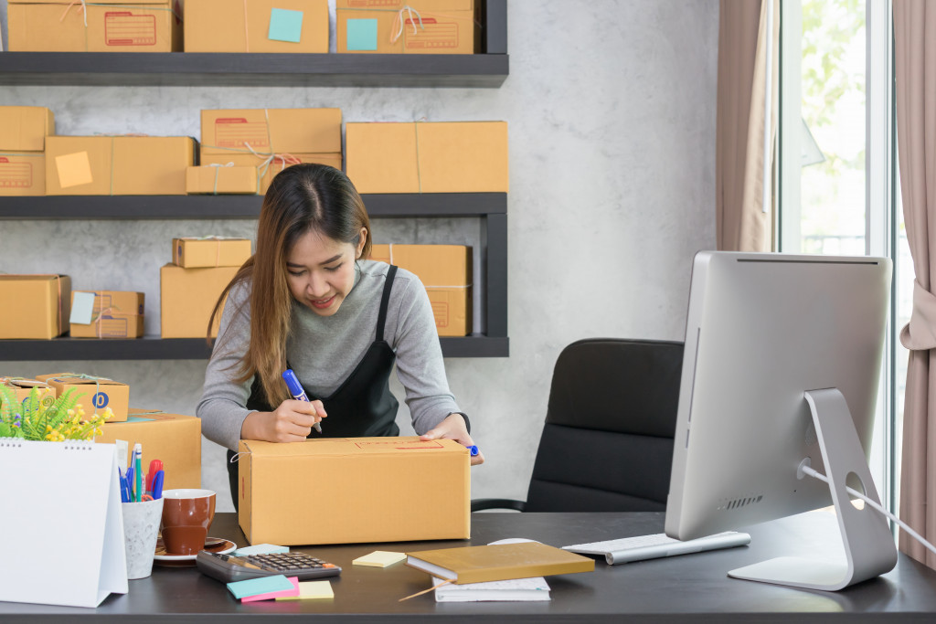 a woman holding a box to ship products