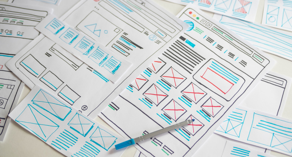 website design plans in different white papers scattered on the table