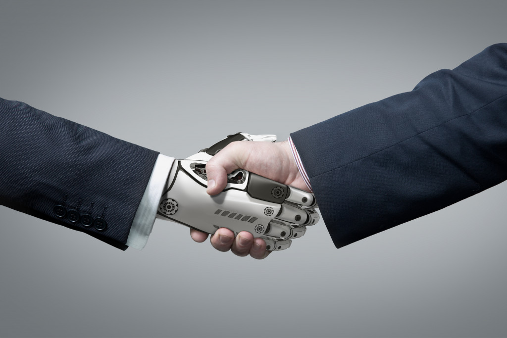 A robotic hand shaking a human hand