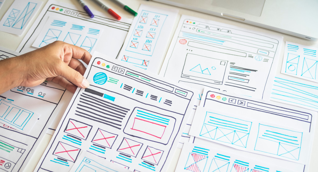 Web designer creating a layout of a website on paper.